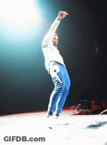 A Man In Blue Sweatpants Is Dancing On Stage GIF