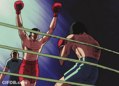 A Man In Boxing Gloves Stands In The Ring With His Hands In The Air GIF