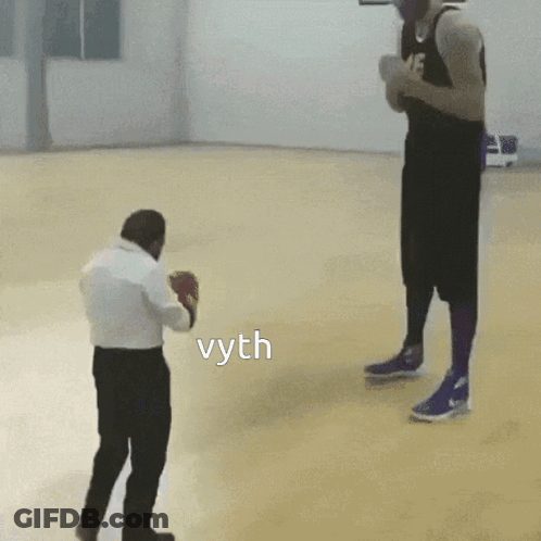 A Man In Boxing Gloves Stands Next To A Man In A Basketball Uniform And The Word Vyth Is On The Floor GIF