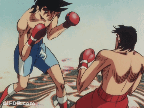 A Man In Boxing Gloves With The Letter T On His Shirt GIF