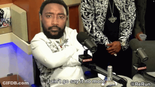 A Man In Front Of A Microphone That Says Revolt On It GIF