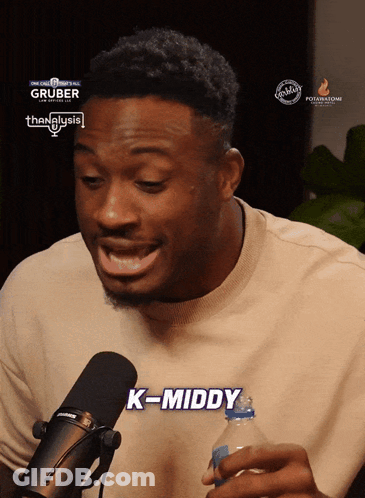 A Man In Front Of A Microphone With The Words K-Middy Written On The Bottom GIF