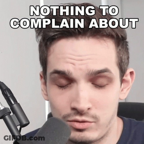 A Man In Front Of A Microphone With The Words Nothing To Complain About Written Above Him GIF