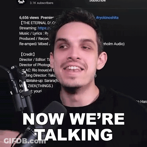 A Man In Front Of A Microphone With The Words Now We 'Re Talking Behind Him GIF