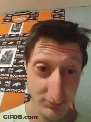 A Man In Front Of A Wall With Denver Broncos Stickers GIF