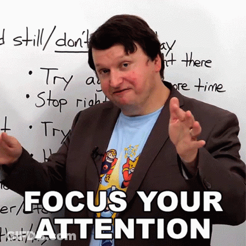 A Man In Front Of A White Board That Says Focus Your Attention On It GIF