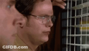A Man In Glasses Is Looking Out Of A Window . GIF