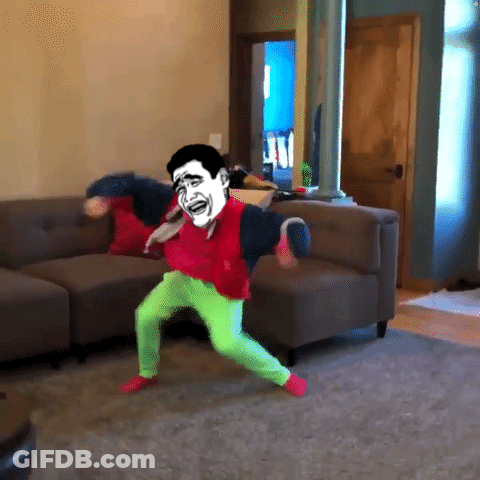 A Man In Green Pants Is Dancing In A Living Room GIF