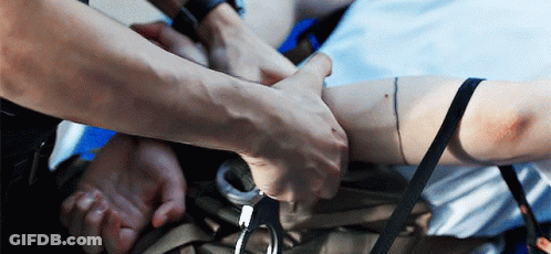 A Man In Handcuffs Is Being Held By Another Person GIF