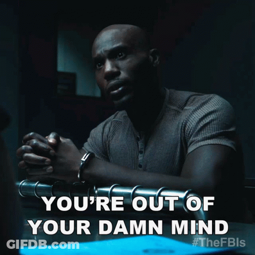 A Man In Handcuffs Is Sitting At A Table With The Words You 'Re Out Of Your Damn Mind GIF