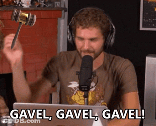 A Man In Headphones Is Holding A Gavel In Front Of A Microphone And Says Gavel Gavel Gavel GIF