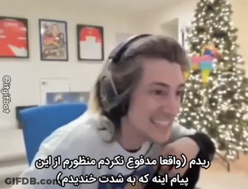 A Man In Headphones Is Smiling In Front Of A Christmas Tree . GIF