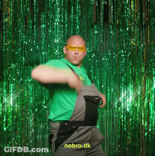 A Man In Overalls Is Dancing In Front Of A Green Curtain That Says Nobro.dk On It GIF