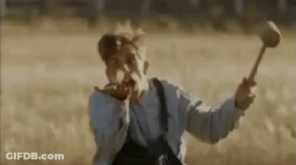 A Man In Overalls Is Holding A Hammer In A Field And Screaming . GIF