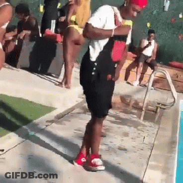 A Man In Overalls Is Standing Next To A Swimming Pool . GIF