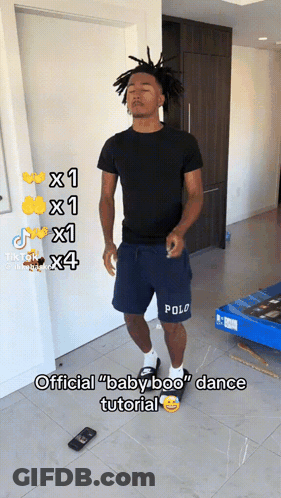 A Man In Polo Shorts Is Standing In A Room GIF