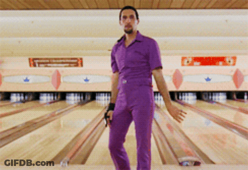 A Man In Purple Overalls Stands In A Bowling Alley GIF