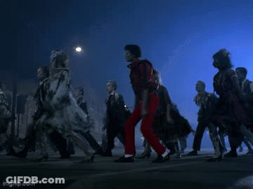 A Man In Red Pants Is Dancing In Front Of A Crowd Of People GIF