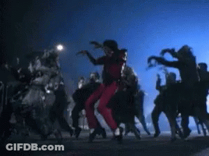 A Man In Red Pants Is Dancing With A Group Of Zombies GIF
