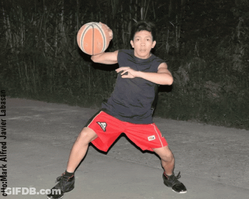 A Man In Red Shorts Is Holding A Basketball In His Hands GIF
