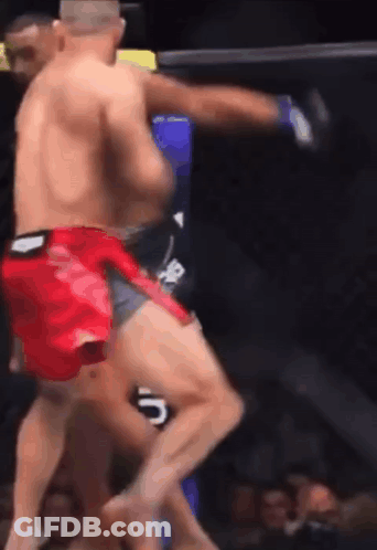 A Man In Red Shorts Is Kicking Another Man In The Face GIF