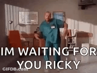 A Man In Scrubs Is Dancing In A Room And Saying `` I 'M Waiting For You Ricky `` . GIF