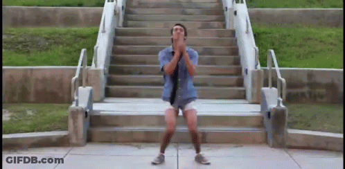 A Man In Shorts And A Tie Is Standing On A Set Of Stairs GIF