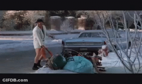 A Man In Shorts Is Shoveling Snow In Front Of A Ford GIF