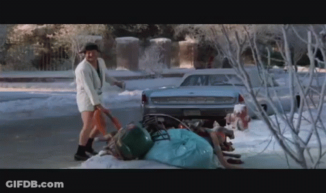A Man In Shorts Is Shoveling Snow In Front Of A Ford GIF
