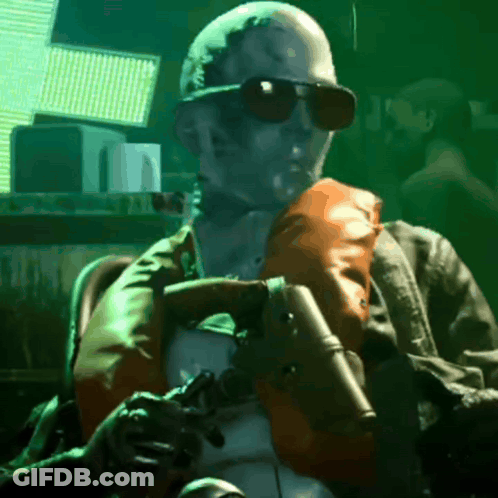 A Man In Sunglasses Is Holding A Gun GIF