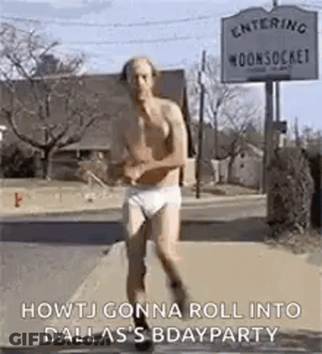 A Man In Underwear Is Running Down A Street . GIF