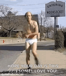 A Man In Underwear Is Running Down The Street . GIF