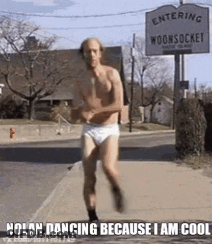 A Man In Underwear Is Running Down The Street . GIF