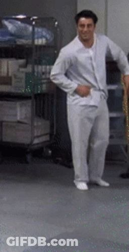A Man In White Pajamas Stands In A Room GIF