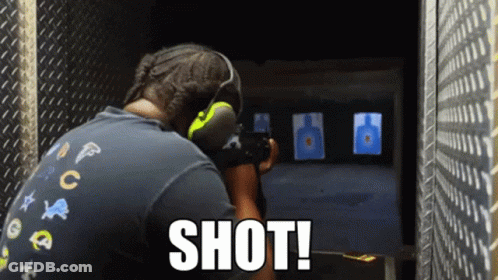 A Man Is Aiming A Gun At A Target And The Word Shot Is On The Bottom Right GIF