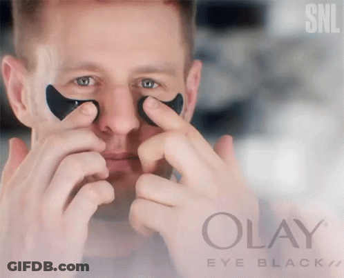 A Man Is Applying Black Eye Patches From Olay Eye Black GIF