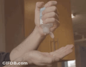 A Man Is Applying Hand Sanitizer To His Hand GIF