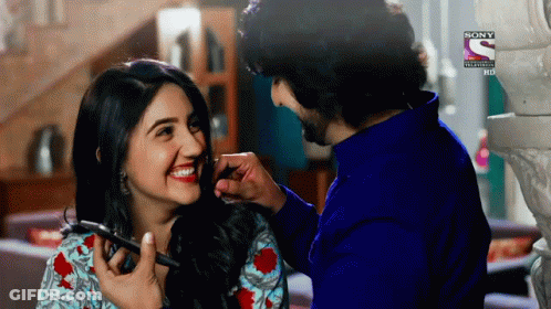 A Man Is Applying Makeup To A Woman 'S Face With A Sony Logo On The Bottom Right GIF