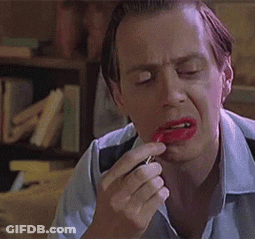 A Man Is Applying Red Lipstick To His Lips And Making A Funny Face . GIF