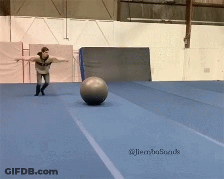 A Man Is Balancing A Ball On A Blue Mat With The Hashtag Jiembasands On The Bottom Right GIF