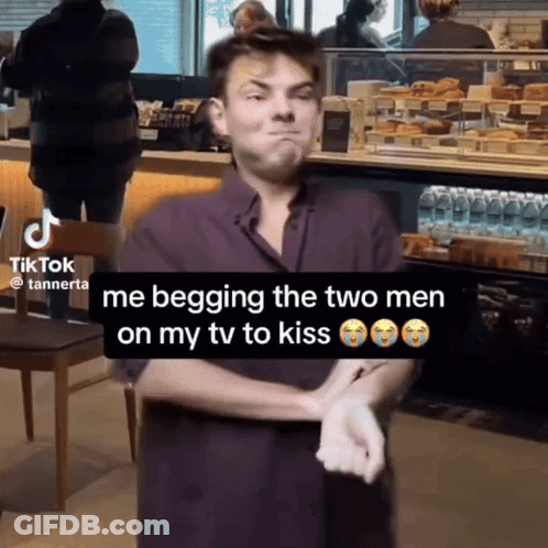 A Man Is Begging The Two Men On His Tv To Kiss In A Tik Tok Video GIF