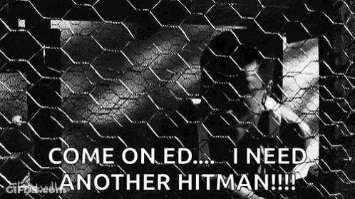 A Man Is Behind A Chain Link Fence And Says `` Come On Ed ... I Need Another Hitman !! '' GIF