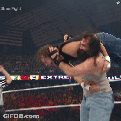 A Man Is Being Lifted In The Air By Another Man In A Wrestling Ring With A Star On The Bottom Right GIF