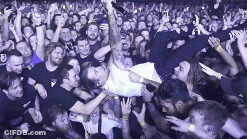 A Man Is Being Lifted Up In The Air By A Crowd Of People GIF