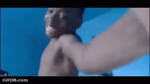A Man Is Being Punched In The Face In A Pool . GIF