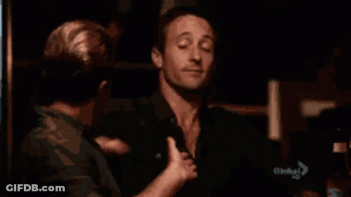 A Man Is Being Touched By Another Man 'S Hand GIF