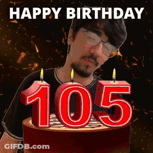 A Man Is Blowing Out Candles On A Birthday Cake With The Number 105 On It GIF
