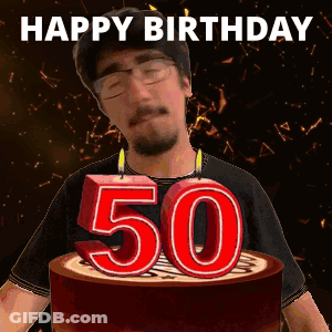 A Man Is Blowing Out Candles On A Cake That Says Happy Birthday GIF