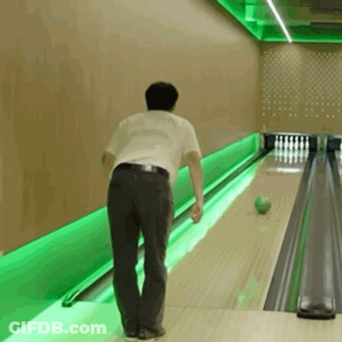 A Man Is Bowling In A Bowling Alley With Green Lights GIF