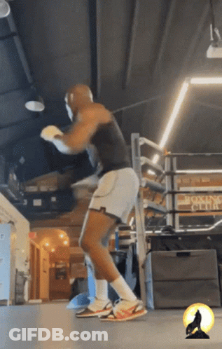 A Man Is Boxing In A Gym With A Sign That Says Boxing Club GIF